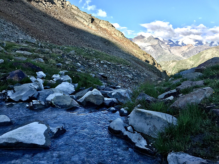 l'acqua in uscita dal laghetto e sullo sfondo il Gruppo del Bernina 