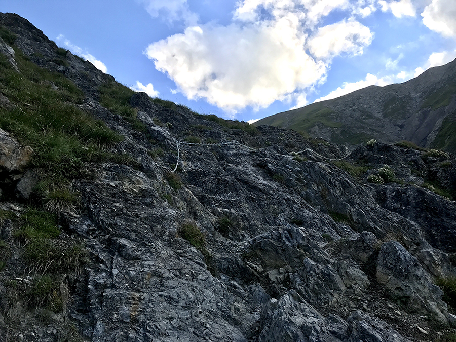 Parte di sentiero con rocce da superare e catena di sicurezza